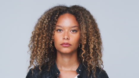 Head-And-Shoulders-Studio-Shot-Of-Woman-Looking-At-Camera-With-Serious-Expression-In-Slow-Motion