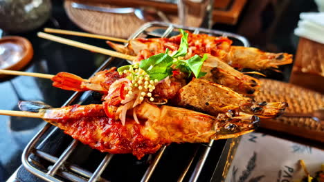 closeup shot of grilled shrimps on skewers garnished with herbs and spices.