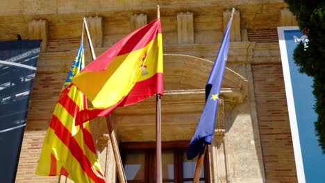 close up shot of valencian, spanish and european flags together