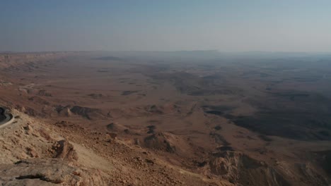 Mitzpe-Ramon-Mitzperamon-Israel-Negev-desert-highway-drone-dolly-in-flying-car-road-mountains-sand-middle-east-middleast-jordan-palestine-crater-Ramon-buildings-stones-stone