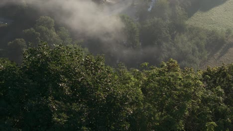 Low-clouds-at-Walzin-castle-Dinant-Belgium-during-sunrise,-aerial