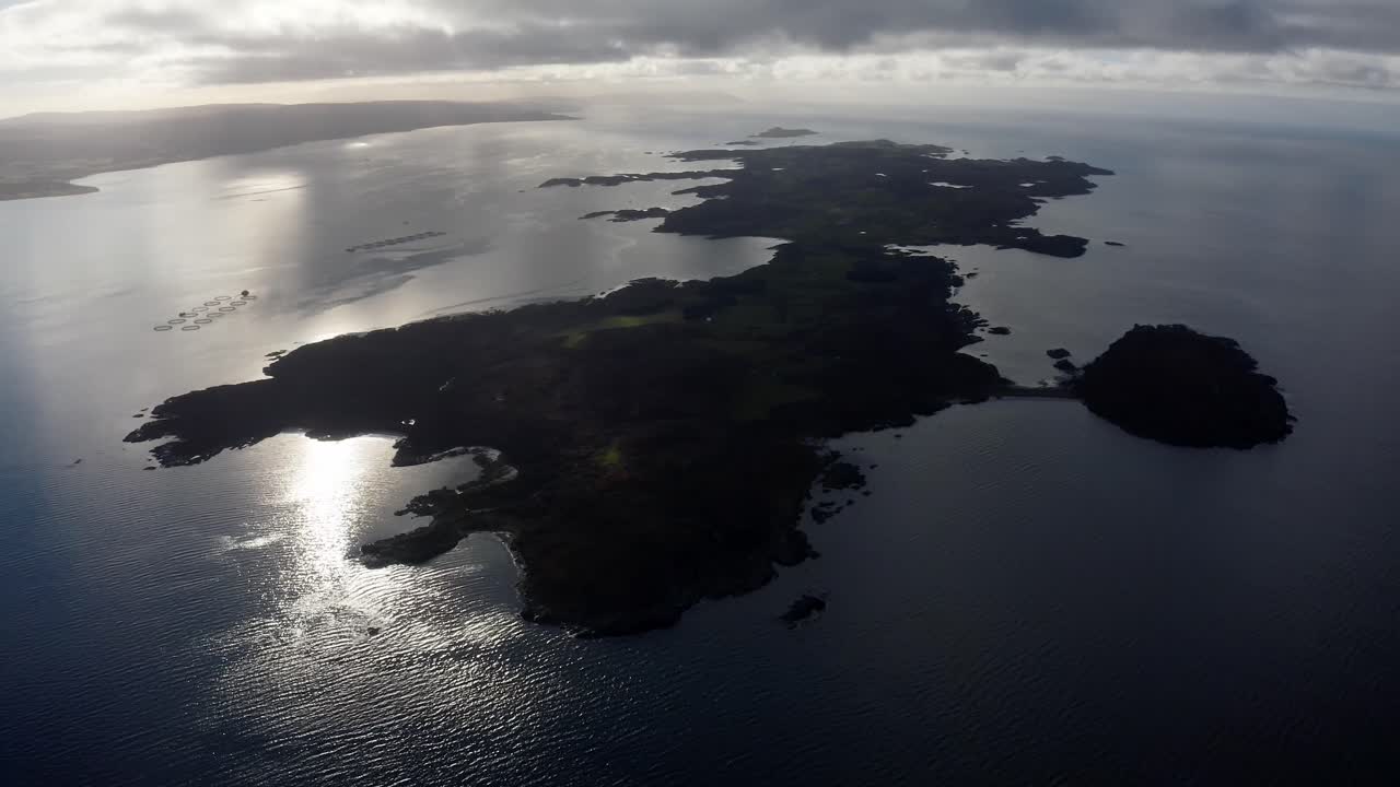 AERIAL - Silhouette of the Isle of Gigha at sunrise, Kintyre, Scotland, ascending