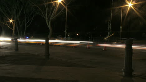 los vehículos aceleran a lo largo de una carretera por la noche en un lapso de tiempo