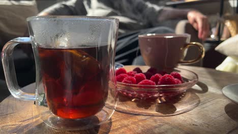 steaming hot tea with rasberries