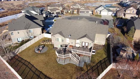 High-altitude-view-of-a-suburban-home-then-descend-to-see-a-mature-man-drinking-a-hot-beverage-in-the-morning-sun