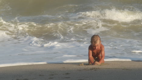 little boy playing near sea