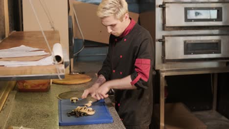 chef preparing pizza toppings in a restaurant kitchen