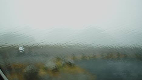 heavy rain falling on a car window