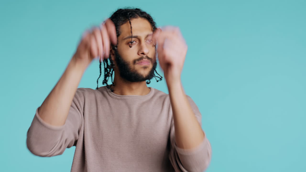 hombre haciendo manos balanceadas, fingiendo dirigir una orquesta, fondo de estudio