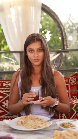 young woman enjoying turkish tea and food