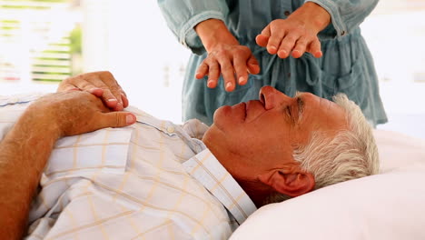 senior man getting reiki therapy