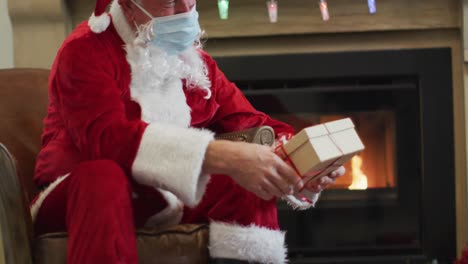 Papá-Noel-Con-Mascarilla-Dando-Caja-De-Regalo