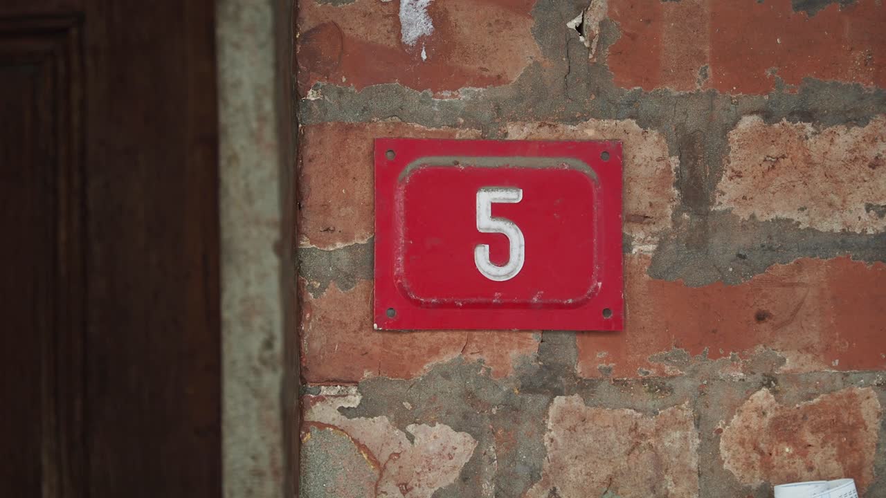 Red Number 5 on a Brick Wall