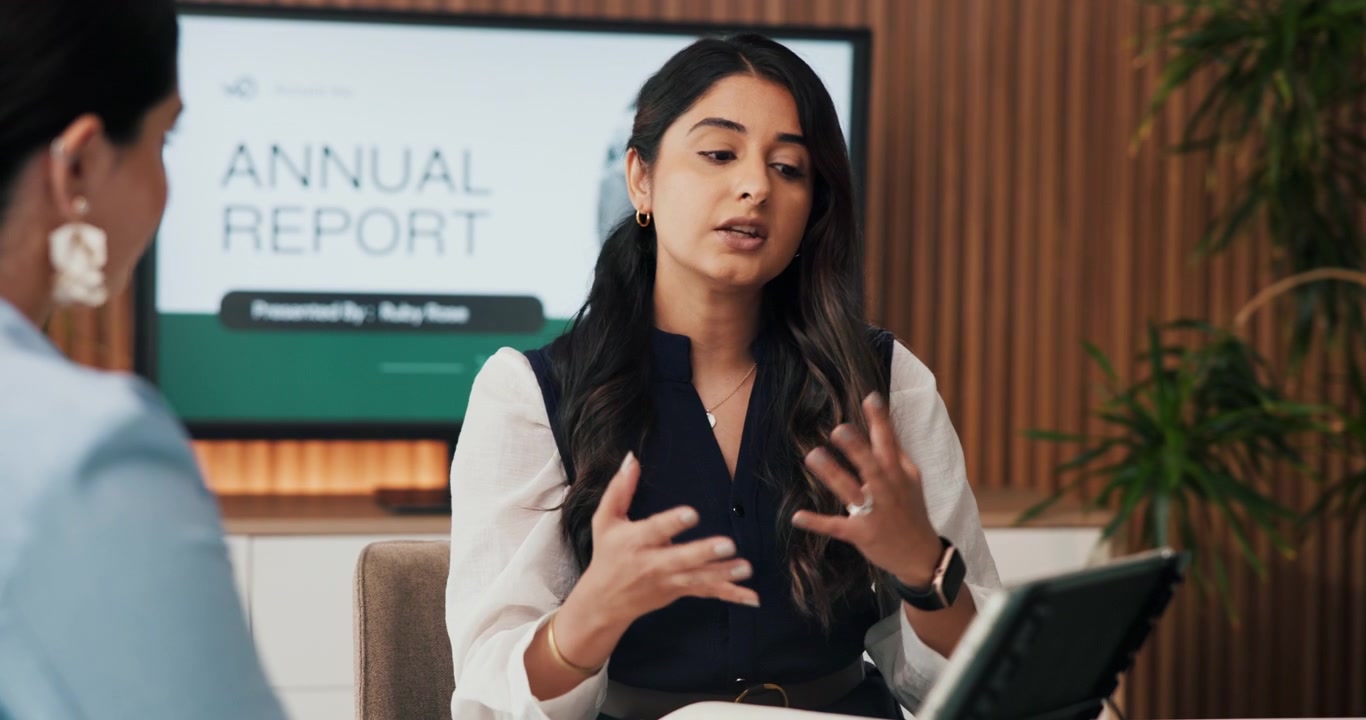 Businesswoman Presenting Annual Report Data to Colleague in Office
