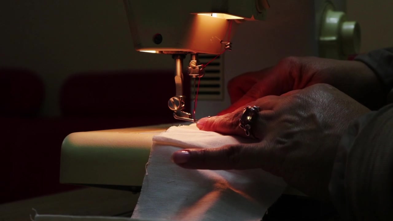 Femme cousant un tissu avec une machine à coudre. Statique