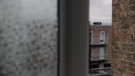 slow reveal of a small window opening, evoking themes of secrecy, spying and hidden observation