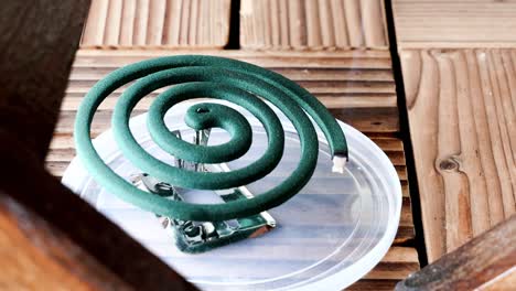 burning mosquito repellent coil with smoke in outdoor setting to ward off mosquitoes