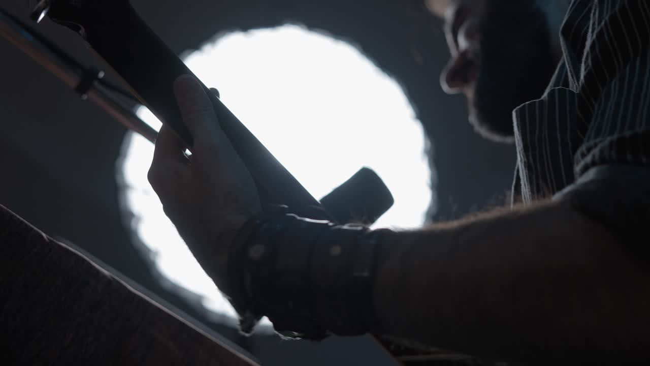 Close-up of a musician playing a bass guitar in a studio