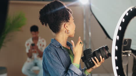 mujer sosteniendo una cámara en un estudio fotográfico