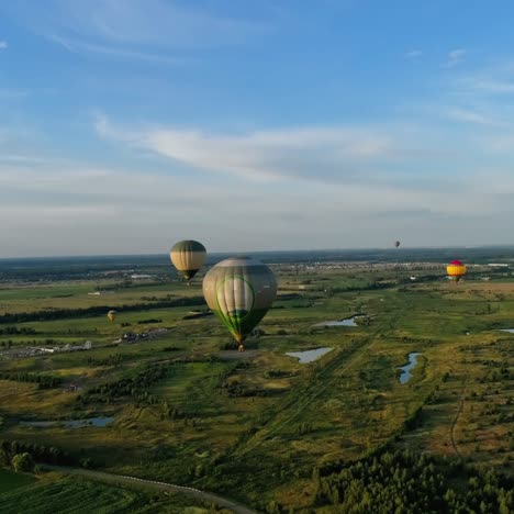 beautiful aerostats in the air. several colorful hot air balloons flying over green fields. aeronautical transport in the sky. aerial view.