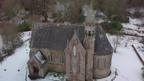 aerial footage of st palladius church in the snow on a winter day in aberdeenshire, scotland