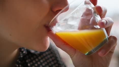 woman drinks fresh orange juice in the morning for vitamins
