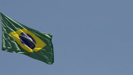 brazilian national flag fluttering in blue sky day