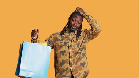 Cheerful-person-holding-shopping-paper-bags-in-studio