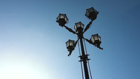 four-lamped street lamp against a clear blue sky