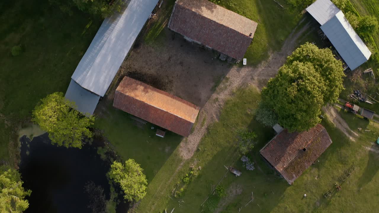 vista aérea de un campo verde, un estanque y una granja en warmia, polonia