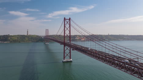 Aerial-view-of-busy-car-traffic-across-famous-red-Ponte-25-de-Abril-bridge-in-Lisbon,-Portugal