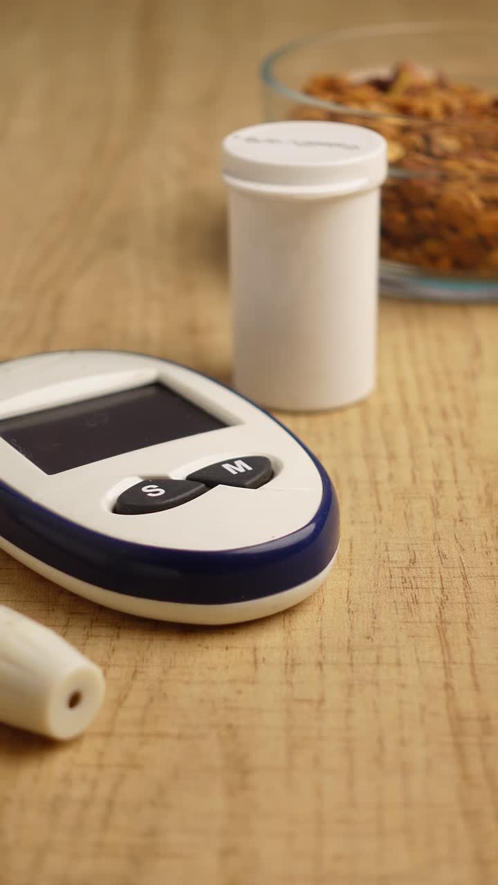 Glucose Meter and Lancet Pen for Diabetes Monitoring on Wooden Table