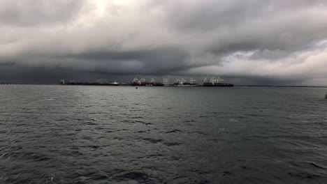 Giant-container-terminal-equipped-with-white-gantry-cranes-loading-and-discharging-containers-from-container-vessels-in-the-port-of-Vancouver-on-a-cloudy-day