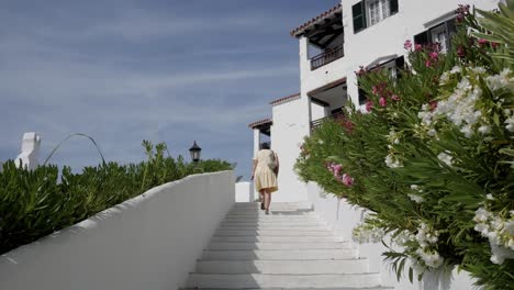 sunlit resort stairs with a woman in a yellow dress walking up, serene and peaceful
