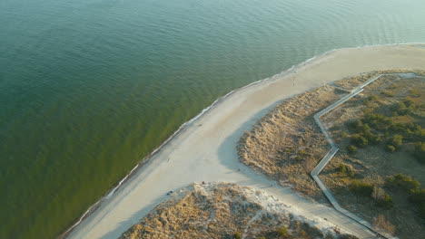 Aerial-drone-shot-of-beautful-coastline-with-sandy-beach-and-calm-Baltic-Sea-in-Summer