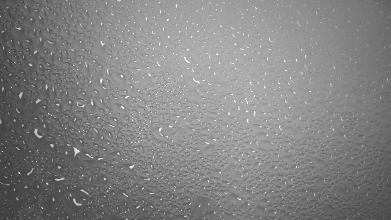 fondo de agua caliente humeante forma muchas gotas de agua en una superficie de vidrio