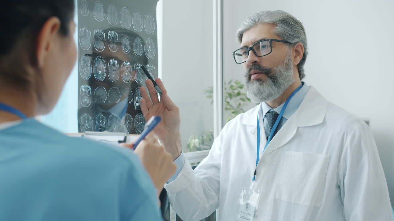 Medico e infermiera che esaminano risonanze magnetiche