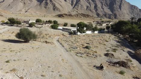 aerial over arid desert landscape towards local village in balochistan