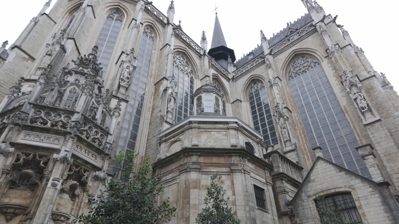 A Gothic church facade with tall stained glass windows and intricate carvings