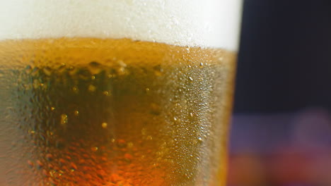 Beer-closeup.-Pint-of-cold-Craft-beer-isolated-on-matte-black-background-rotation-360-degrees.-Glass-of-beer-with-water-drops.