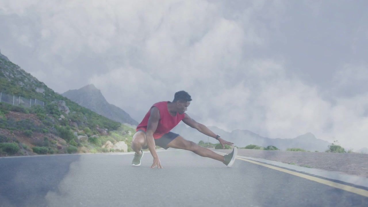 Homem deslocando o peso, deslizando para um alongamento lateral em estrada de montanha, neblina subindo sob os pés para fitness.