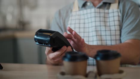 Caucasian-man-with-down-syndrome-accepting-contactless-payment-in-the-cafe.