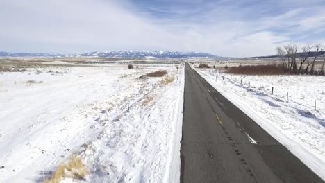 drone starts low above the road, then raises to show vast landscape