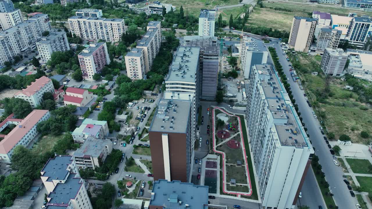 Vista aérea mostrando a transição de edifícios altos urbanos para campos verdes rurais, ilustrando o contraste entre cidade e campo