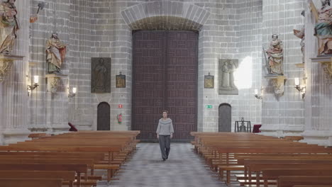 woman walks down aisle of the jerez de la frontera cathedral - frontal