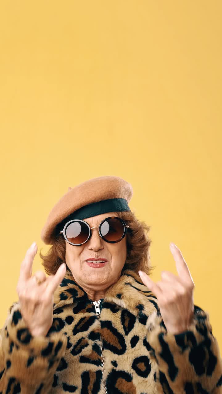 Cool Elderly Woman in Leopard Print and Beret Making Rock On Gesture