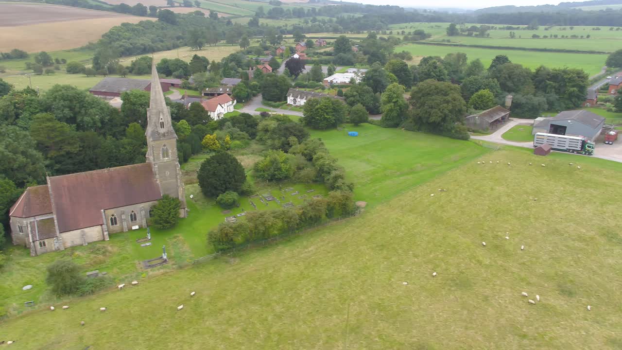 Droonivideo panoroi viljelysmaan yli, näyttäen maatalouskuorma-auton ajavan tietä ylös hakemaan sikoja maaseututilalta Yorkshiressä, Isossa-Britanniassa.