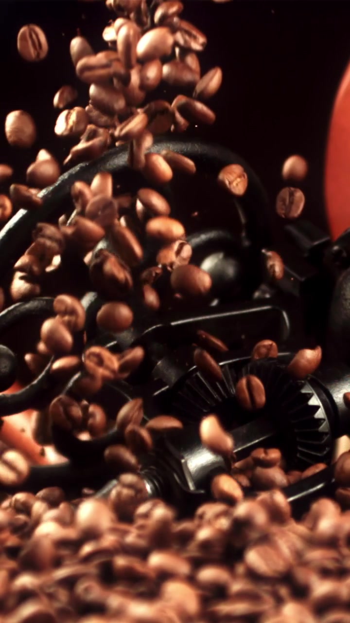 Chicchi di caffè tostati che cadono al rallentatore con un macinacaffè