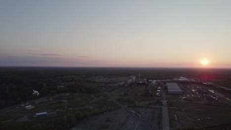 drone capture urban town surrounded by tree and the sun setting in the horizon