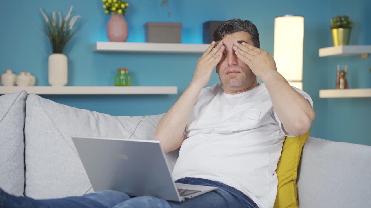 el hombre frotándose los ojos de agotamiento.